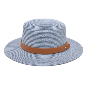 Detail of light blue straw boater hat featuring a brown leather band and gold rivet