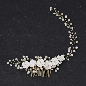 Detailed view of handmade bridal hair comb with ceramic flowers, pearls and crystals
