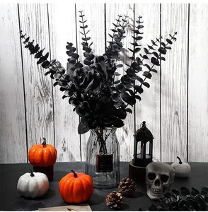 Black artificial rose and eucalyptus bouquet in a glass vase for Halloween decor