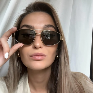 Detail of gold metal double-bridge pilot sunglasses with oversized dark brown lenses