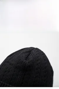Close-up of the thick knit texture and warm material on this black beanie cap