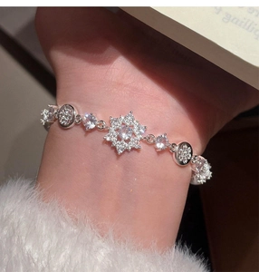 Close-up of silver-tone flower bracelet featuring sparkling zircon and pearl details