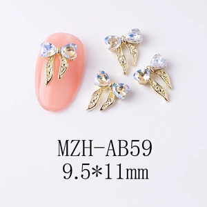 Détail d'un nœud doré avec strass en cœur sur une manucure rose délicate
