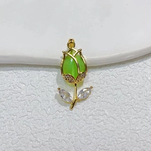 Detailed macro view of a gold-plated tulip pendant with green cat-eye stone and zircons