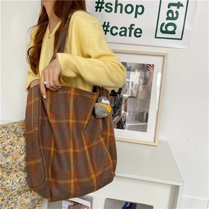 Casual plaid wool tote bag styled with a yellow knit sweater and cute penguin charm