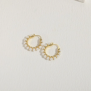 Close-up of 14K gold plated hoop earrings with delicate white pearls on white background