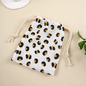 Detail of drawstring storage bag in white muslin cotton with leopard print and cotton rope