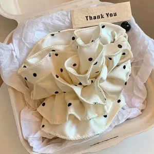 Chouchou géant à pois en satin crème présenté dans une boîte cadeau élégante
