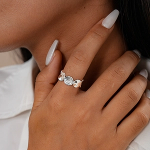 Nahaufnahme eines silbernen geometrischen Rings mit Hammerschlag-Textur am Finger