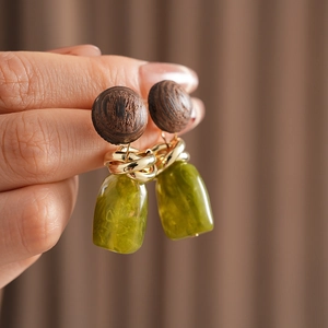 Detail of vintage geometric earrings with wood circles and green resin drops
