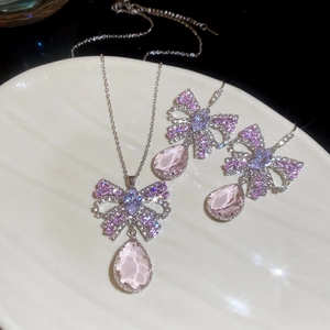 Detailed view of silver butterfly necklace and earrings with pink and blue zircons