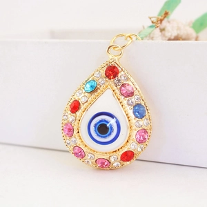 Golden teardrop evil eye charm with colorful rhinestones and blue central jewel