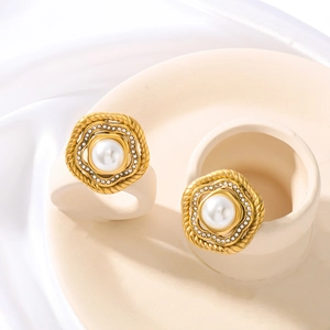 Golden flower earrings with pearl and rhinestones on ceramic tray with silk