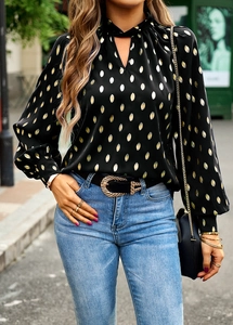 Detail of long sleeve black shirt with golden polka dots and halter neck design