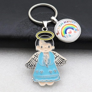 Detail view of silver angel pendant and Schulkind rainbow charm keychain on leather