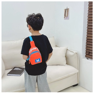 Détail du sac de poitrine en nylon orange vif pour enfant avec inscription Sport
