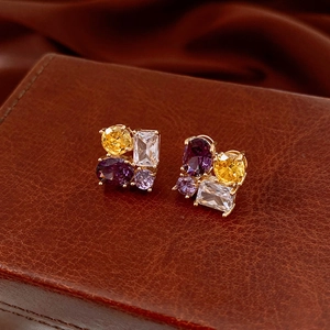 Macro shot of oval cubic zirconia earrings with multi-colored stones on premium leather