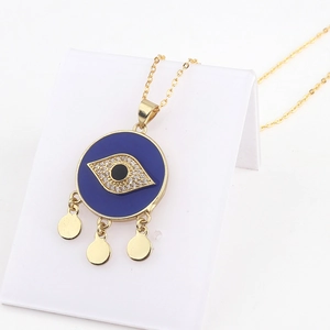 Macro detail of 18k gold evil eye heart pendant necklace with blue crystals