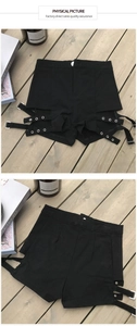 Dettaglio di pantaloncini neri a vita alta con occhielli in metallo e cinturini regolabili