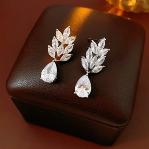 Macro shot of leaf zircon cluster earrings and pear-shaped droplet pendant details