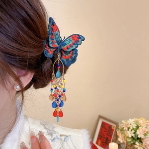 Detailed view of an embroidered butterfly hair clip with crystal tassels and colorful beads