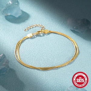 Minimalist triple-strand gold 925 sterling silver snake bone chain bracelet on blue background