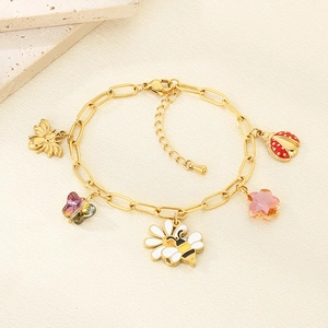 Detailed view of gold stainless steel bracelet with bee, daisy and ladybug enamel charms