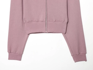 Détail d'un sweat à capuche lavande montrant le zip en métal et l'ourlet côtelé
