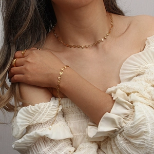 Golden heart jewelry set including necklace and bracelet worn on female model