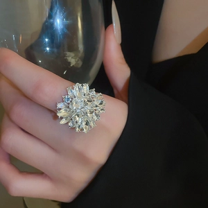 Sparkling crystal flower ring shown in a luxury party setting with a wine glass