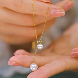 Exquisite French pearl pendant necklace in gold titanium steel on a female model