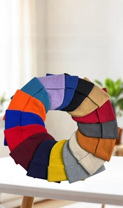 Vari colori di berretti in maglia a tinta unita disposti a cerchio per il caldo inverno
