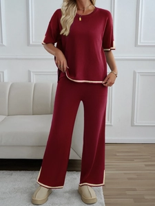 Detail view of burgundy knit two-piece set featuring contrast beige trim and wide-leg pants
