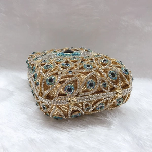 Luxury gold hollow metal evening clutch bag with crystal eye pattern on white fur