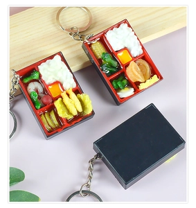 Detailed view of miniature food bento box keychains with realistic rice and shrimp