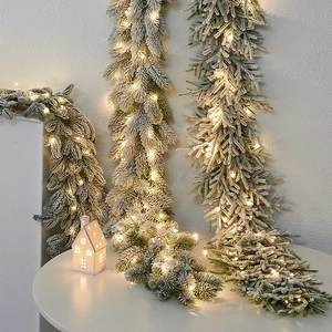 Ghirlanda natalizia floccata illuminata con luci LED calde ed effetto neve artificiale