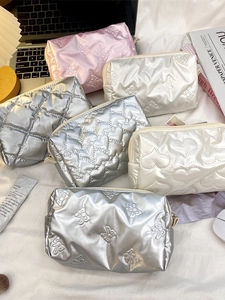 Metallic heart and bow quilted makeup bags in pink, silver, and white with zipper closures