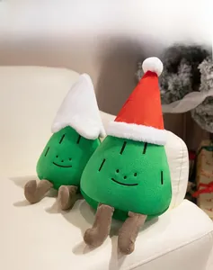 Close-up of a cute plush Christmas tree toy with an embroidered smiley face on a sofa