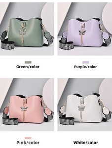Detail view of bow pendant handbags in green, purple, pink, and white with striped straps