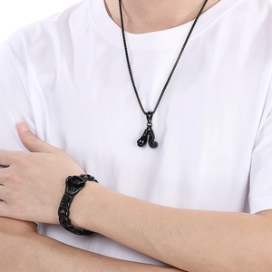 Detail of black boxing glove pendant necklace and matching curb chain bracelet on model