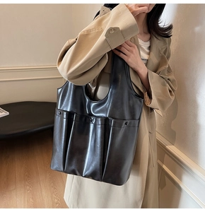 Close-up of black PU leather tote bag featuring a practical vertical side storage pocket