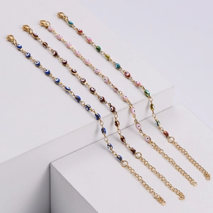 Macro shot of assorted Evil Eye charm bracelets with gold-plated chains and enamel beads