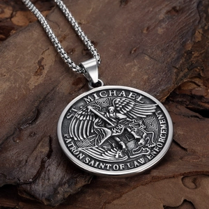 Macro view of St. Michael Saint of Law Enforcement silver relief pendant on a dark wood background
