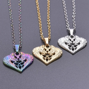 Detailed macro view of heart-shaped wolf head pendants in gold silver and rainbow finishes