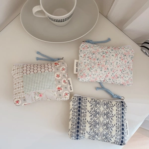 Detailed view of three quilted floral mini pouches for earphones and lipsticks