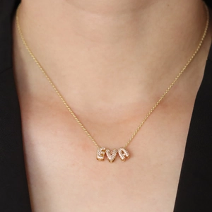 Close-up of gold EVA nameplate necklace with shimmering pavé cubic zirconia stones