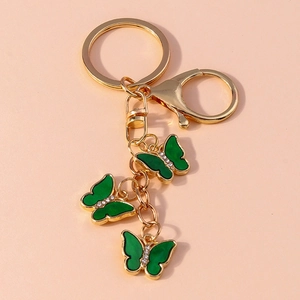 Macro shot of three green butterfly pendants with gold lobster clasp and rhinestones