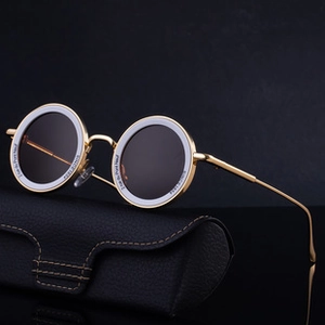 Detail of metal temple and engraved frame text on luxury round frameless sunglasses
