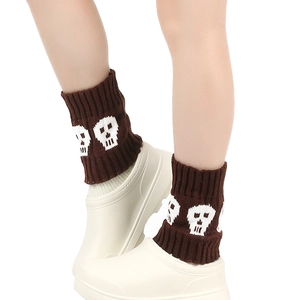 Detail showing brown knitted leg warmers with white skull pattern worn with boots