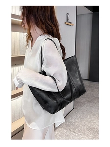 Fashionable black oil wax leather tote bag shown on model for daily lifestyle use